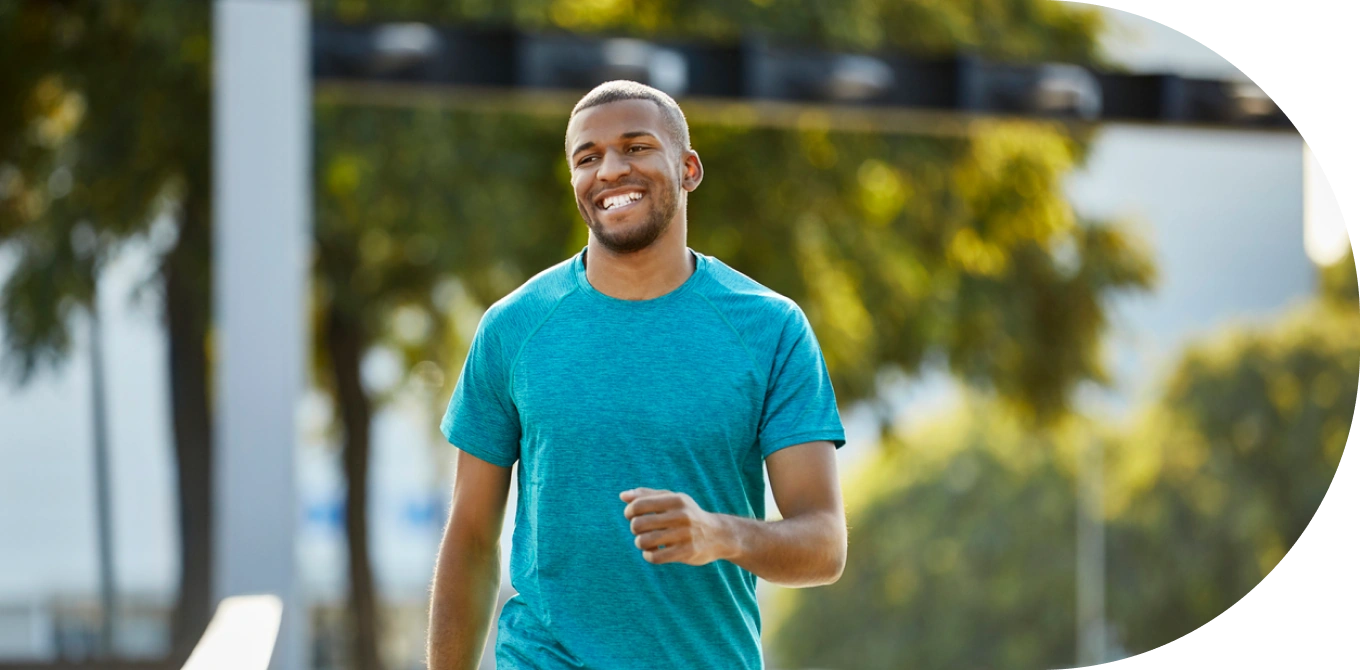 Homem negro praticando caminhada e sorrindo
